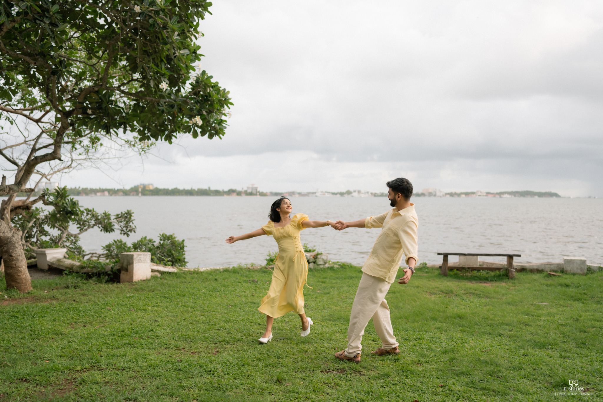 Deepak and Divyendu holding hands beside the water